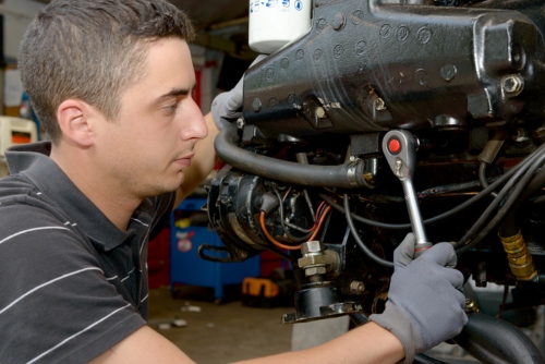 A young man mechanic repairing  motor boats and other